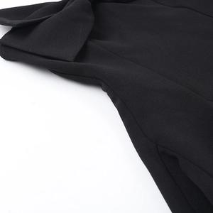 Detail of the high-quality black textured woven fabric and the strapless neckline tailoring