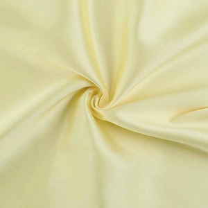 Detailed view of smooth light yellow satin fabric with soft glossy texture and elegant folds