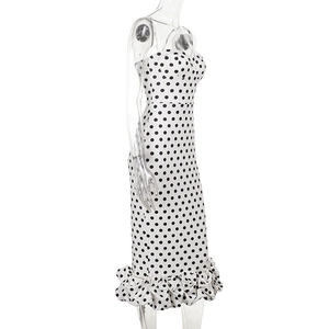 Detail view of white polka dot dress featuring a stylish ruffled hem and slim fit