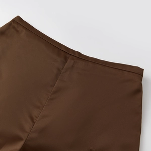 Close-up of deep brown satin shorts featuring smooth fabric texture and precise stitching