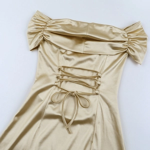 Detailed close-up of champagne satin dress with elegant lace-up back design