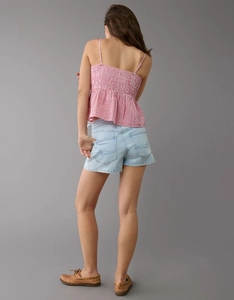 Back view of red checkered camisole with ruffled hem and light blue denim shorts
