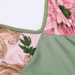 Detail of floral print fabric with dark green trim on a slim A-line summer dress