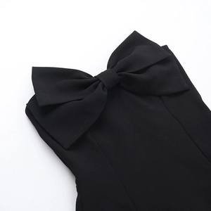 Close-up of the large black bow detail on a strapless dress with matte fabric texture