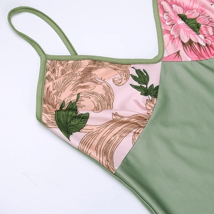 Detail of green satin dress with pink floral patterns and delicate shoulder straps
