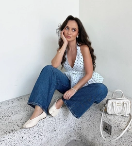Elegant white polka dot halter neck top paired with loose jeans and tabi-style shoes