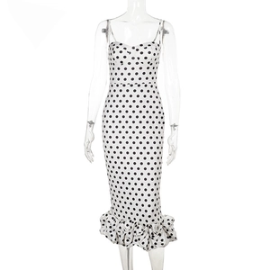Detailed view of white polka dot dress with ruffle fishtail hem and slim fit silhouette