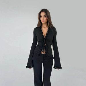 Detailed view of elegant black chiffon top featuring lace trim and flared bell sleeves