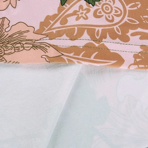 Detail of pink paisley dress with green double-stitch sewing and chiffon texture