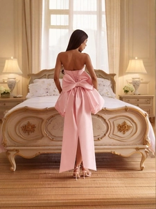 Pink satin strapless gown with large bow and lace-up back design in elegant room