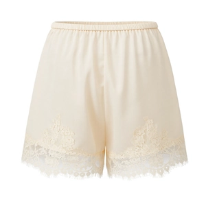 Detail of elegant cream satin shorts featuring delicate eyelash lace hem and elastic waist