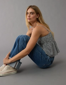 Detail of smocked gingham tube top with adjustable straps and cuffed straight leg jeans