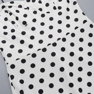 Detail of sweetheart neckline and black polka dots on white A-line party dress