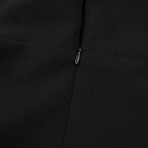 Detail of invisible zipper closure on a black A-line dress with woven fabric texture