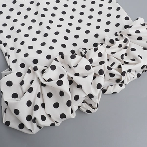 Detail of the black and white polka dot fabric with layered ruffles and pleats