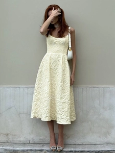 Detailed view of the pale yellow midi dress featuring intricate 3D jacquard texture