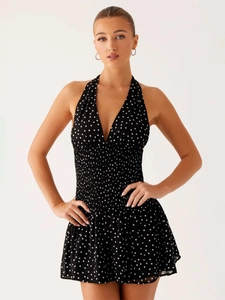 Detailed close-up of smocked waist and polka dot pattern on the halter neck dress