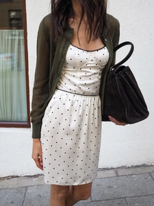 Gros plan d'une robe blanche à pois avec dentelle noire et cardigan en maille