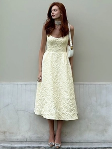 Detail of light yellow jacquard sleeveless dress with 3D floral texture and A-line waist