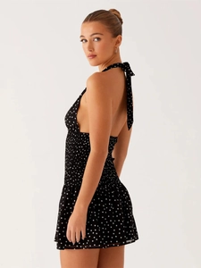 Detailed back view of a polka dot halter dress with a bow tie and elastic pleats