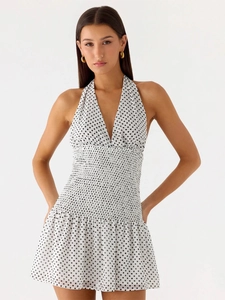 Close-up of smocked waist detail on white polka dot halter dress with V-neckline