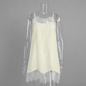 Detail of delicate white lace trim on a cream-colored sleeveless cotton dress