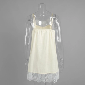 Close-up of delicate eyelash lace trim and textured fabric on the hem of a beige slip dress