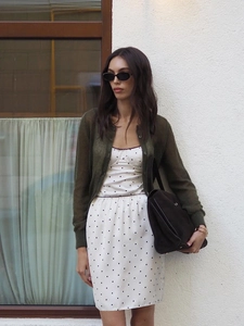 Robe blanche à pois avec cardigan vert foncé cintré et un grand sac à main noir