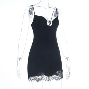 Détail de la mini robe noire moulante avec ourlet en dentelle et décolleté lacé en V