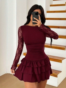 Detailed macro view of burgundy lace sleeves and layered pleated hem of the dress