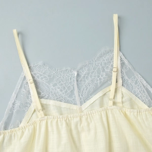 Detail of light yellow dress with delicate white eyelash lace and adjustable straps