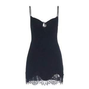 Détail d'une mini robe noire avec bordure en dentelle et découpe à lacet sur le buste