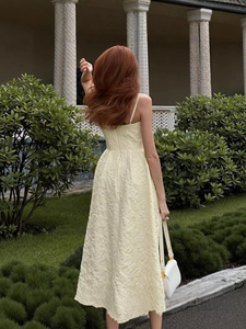 Elegant light yellow floral textured strapless midi dress in a scenic garden setting