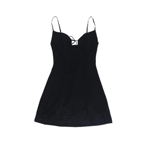 Détail d'une mini robe noire avec bordure en dentelle et laçage au niveau du décolleté