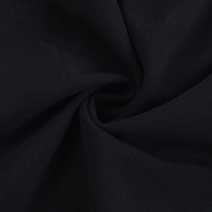 Vue macro détaillée montrant la texture et le drapé doux du tissu mousseline noir de la robe