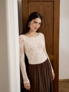 Close-up of white floral lace long-sleeve bodysuit and high-waist brown skirt