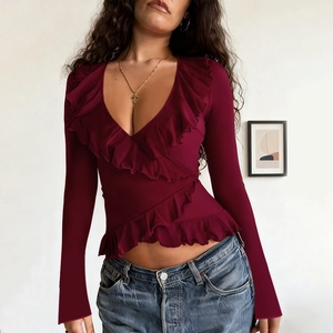 Close-up of deep wine red long sleeve top with ruffles and a deep V-neckline