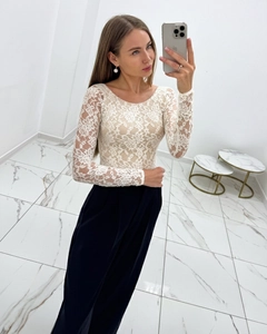 Detail of elegant white floral lace top with semi-transparent long sleeves and slim fit