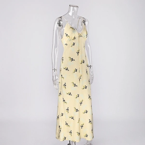 Détail d'une robe longue fleurie jaune avec bordure en dentelle blanche sur le décolleté