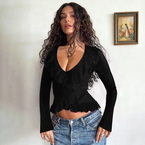 Detail of deep V-neckline and delicate ruffles on a slim-fit black long-sleeve top