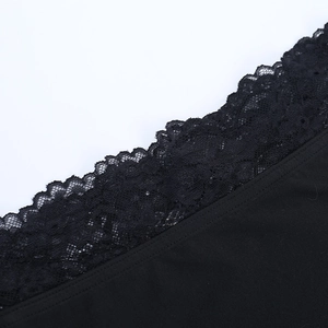 Detailed close-up of intricate black floral lace trim and stitching on the garment edge