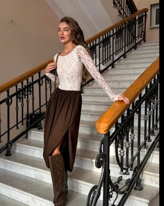 Detail of white floral lace top paired with a deep brown high-slit midi skirt