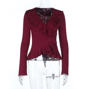 Close-up of deep red V-neck top showing ruffle trim and soft knit fabric texture