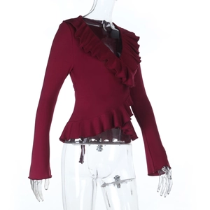 Detail of dark red wrap top featuring delicate ruffles and V-neckline long sleeves