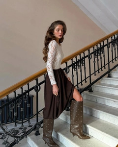 Detail of elegant white lace floral long sleeve top paired with dark brown maxi skirt