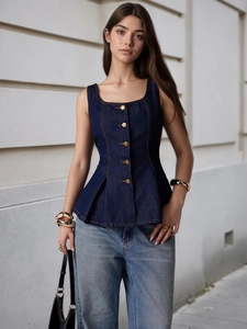 Detailansicht des dunkelblauen Denim-Schößchen-Tops mit goldenen Zierknöpfen und Nähten