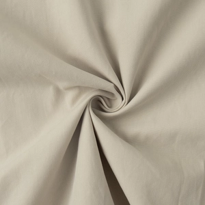 Close-up of beige breathable cotton fabric texture showing clear weave and soft drape