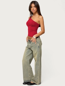 Detail of red asymmetric one-shoulder slim top paired with vintage wide-leg jeans