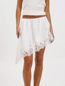 Elegante minigonna di raso bianco con orlo in pizzo asimmetrico e vita elastica da donna