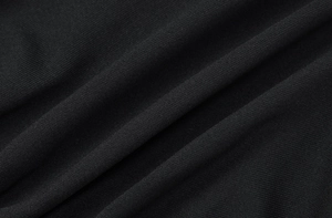 Gros plan macro du tissu en maille noire haute densité montrant le tissage fin et les plis